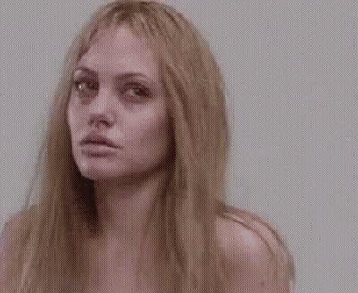 A Close Up Of A Woman 'S Face With Long Blonde Hair Without Makeup . GIF