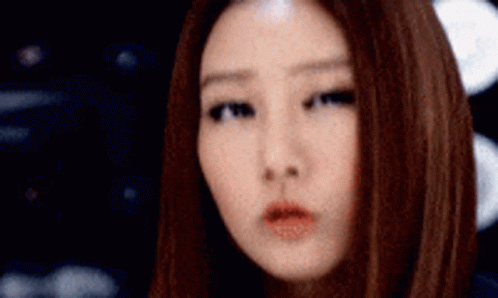 A Close Up Of A Woman 'S Face With Long Brown Hair GIF
