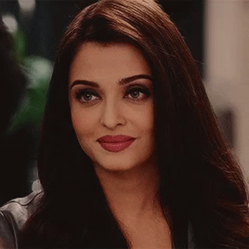 A Close Up Of A Woman 'S Face With Long Brown Hair And Red Lips . GIF