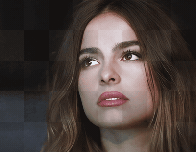 A Close Up Of A Woman 'S Face With Long Brown Hair GIF