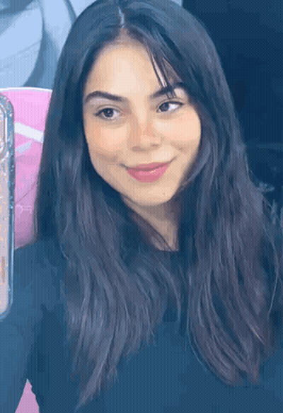 A Close Up Of A Woman 'S Face With Long Dark Hair And A Smile . GIF