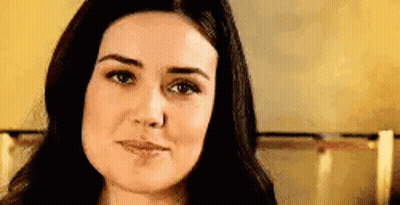 A Close Up Of A Woman 'S Face With Long Dark Hair . GIF
