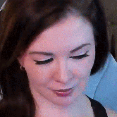 A Close Up Of A Woman 'S Face With Long Eyelashes And A Smile . GIF