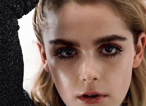 A Close Up Of A Woman 'S Face With Long Eyelashes GIF