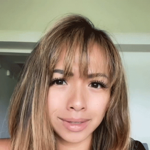 A Close Up Of A Woman 'S Face With Long Hair GIF
