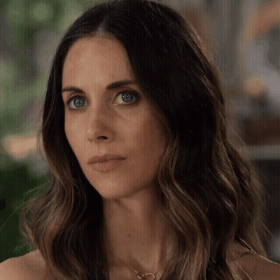 A Close Up Of A Woman 'S Face With Long Hair GIF