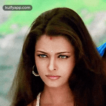 A Close Up Of A Woman 'S Face With Long Hair And A Red Spot On Her Forehead . GIF