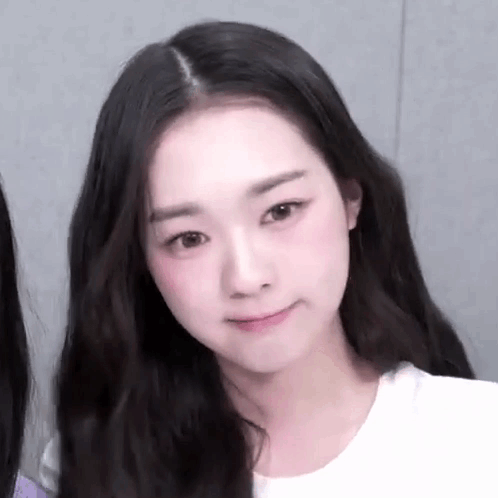 A Close Up Of A Woman 'S Face With Long Hair And A White T-Shirt . GIF