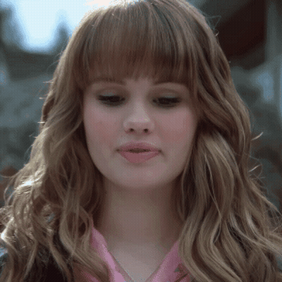 A Close Up Of A Woman 'S Face With Long Hair And Bangs GIF