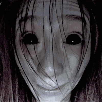 A Close Up Of A Woman 'S Face With Long Hair And Black Eyes . GIF
