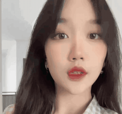 A Close Up Of A Woman 'S Face With Long Hair And Red Lips GIF