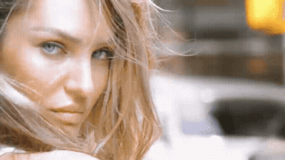 A Close Up Of A Woman 'S Face With Long Hair Blowing In The Wind . GIF