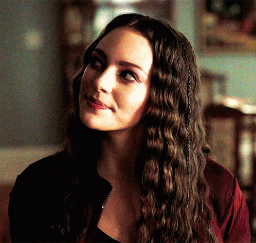 A Close Up Of A Woman 'S Face With Long Hair GIF