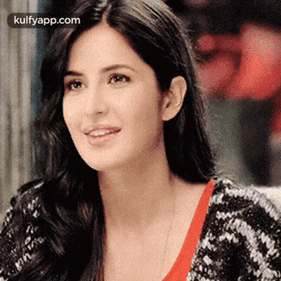 A Close Up Of A Woman 'S Face With Long Hair Wearing A Black And White Sweater . GIF
