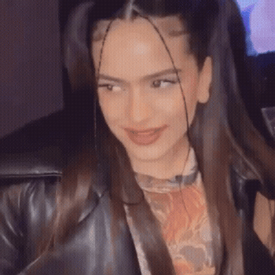 A Close Up Of A Woman 'S Face With Pigtails And A Leather Jacket On . GIF