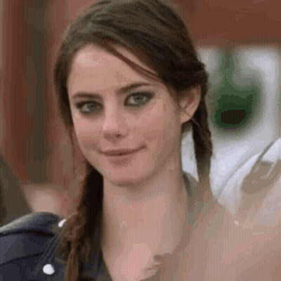 A Close Up Of A Woman 'S Face With Pigtails Smiling . GIF