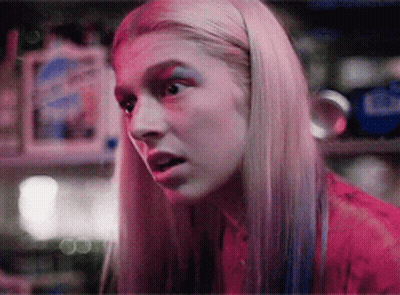 A Close Up Of A Woman 'S Face With Pink And Blue Makeup GIF