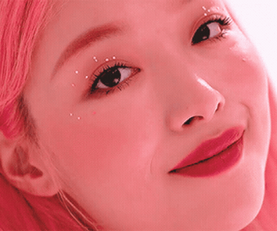 A Close Up Of A Woman 'S Face With Pink Hair . GIF
