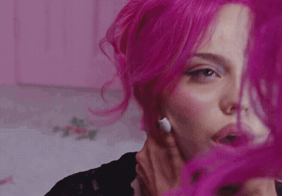 A Close Up Of A Woman 'S Face With Pink Hair GIF