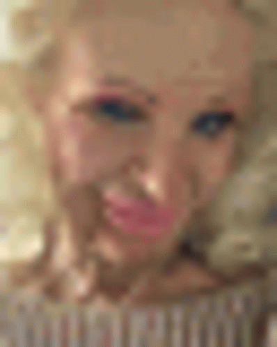 A Close Up Of A Woman 'S Face With Pink Lips And A Tattoo On Her Forehead . GIF
