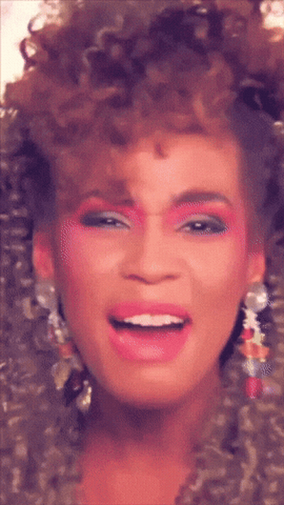 A Close Up Of A Woman 'S Face With Pink Makeup And Earrings GIF