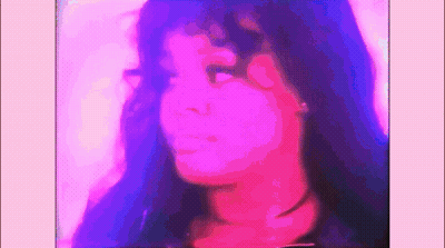 A Close Up Of A Woman 'S Face With Purple And Pink Lighting Behind Her . GIF