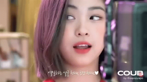 A Close Up Of A Woman 'S Face With Purple Hair Making A Funny Face . GIF