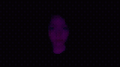 A Close Up Of A Woman 'S Face With Purple Lights Behind Her . GIF