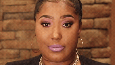 A Close Up Of A Woman 'S Face With Purple Lipstick And Hoop Earrings . GIF