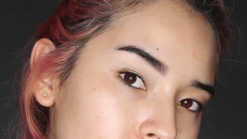 A Close Up Of A Woman 'S Face With Red Hair And Brown Eyes GIF