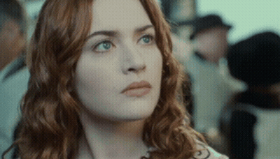 A Close Up Of A Woman 'S Face With Red Hair And Green Eyes GIF