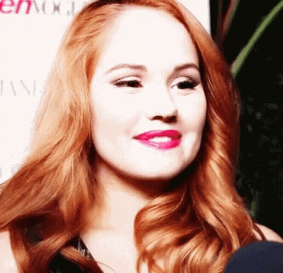 A Close Up Of A Woman 'S Face With Red Hair And Pink Lips GIF