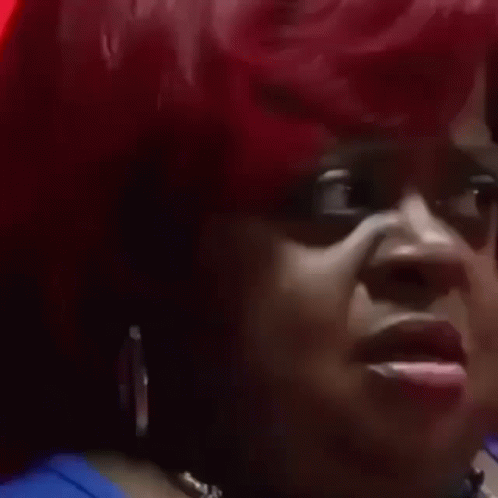 A Close Up Of A Woman 'S Face With Red Hair Making A Funny Face . GIF