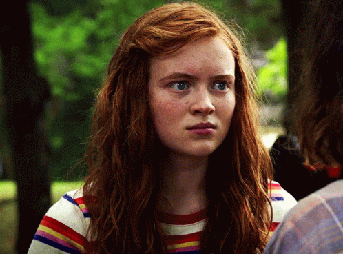 A Close Up Of A Woman 'S Face With Red Hair Wearing A Striped Shirt GIF