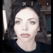 A Close Up Of A Woman 'S Face With Red Lips And A Black Shirt . GIF