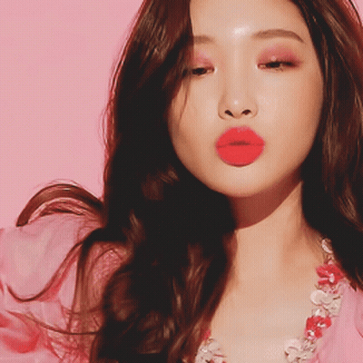 A Close Up Of A Woman 'S Face With Red Lips And A Pink Background GIF