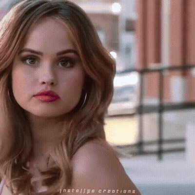 A Close Up Of A Woman 'S Face With Red Lipstick And Hoop Earrings GIF