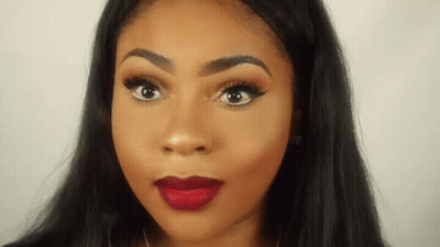 A Close Up Of A Woman 'S Face With Red Lipstick And Long Black Hair . GIF