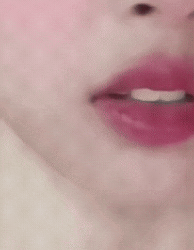 A Close Up Of A Woman 'S Face With Red Lipstick And White Teeth GIF