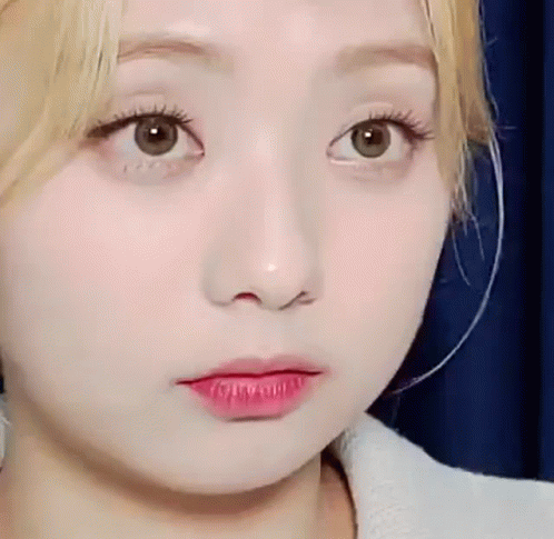 A Close Up Of A Woman 'S Face With Red Lipstick On Her Lips And A Blue Background . GIF