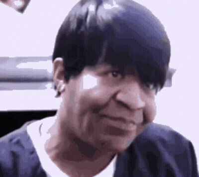 A Close Up Of A Woman 'S Face With Short Black Hair . GIF
