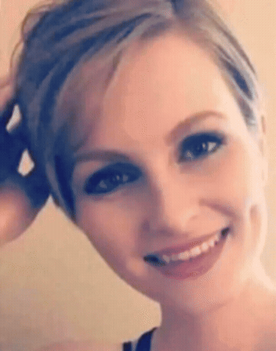 A Close Up Of A Woman 'S Face With Short Hair And A Smile On Her Face . GIF