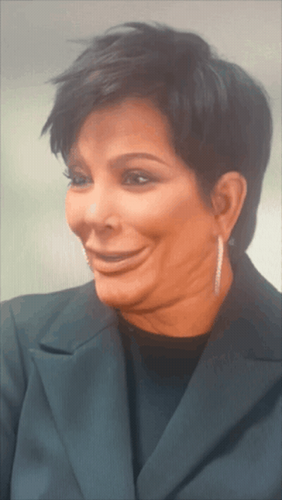 A Close Up Of A Woman 'S Face With Short Hair And Earrings GIF