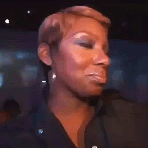 A Close Up Of A Woman 'S Face With Short Hair And Earrings . GIF