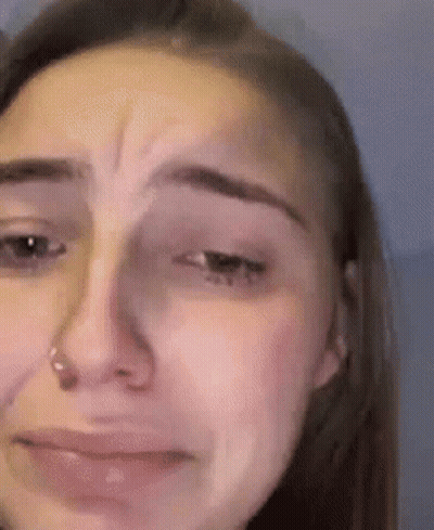 A Close Up Of A Woman 'S Face With Tears Running Down Her Cheeks . GIF