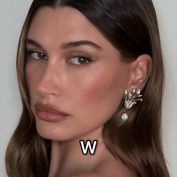 A Close Up Of A Woman 'S Face With The Letter W Next To Her Neck GIF