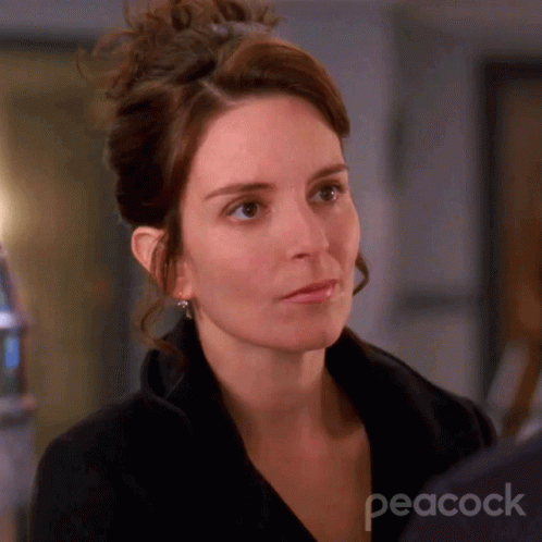 A Close Up Of A Woman 'S Face With The Peacock Logo Behind Her GIF