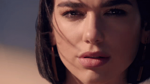 A Close Up Of A Woman 'S Face With The Sun Shining On Her Face GIF