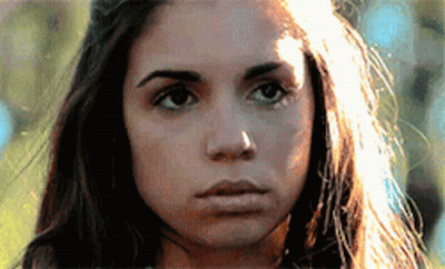 A Close Up Of A Woman 'S Face With The Sun Shining On Her Hair GIF