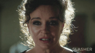 A Close Up Of A Woman 'S Face With The Word Slasher Behind Her GIF